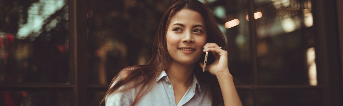 Woman talking on a phone at a café.