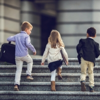 Kids walking up stairs in business clothes